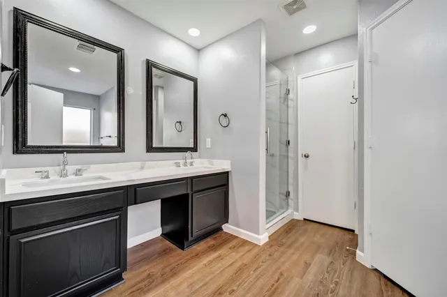 a bathroom with a double vanity sink mirror and shower
