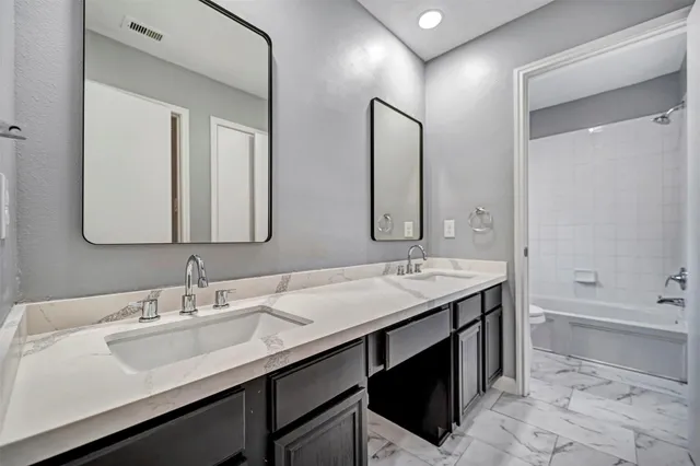 a bathroom with a double vanity sink mirror double and bathtub
