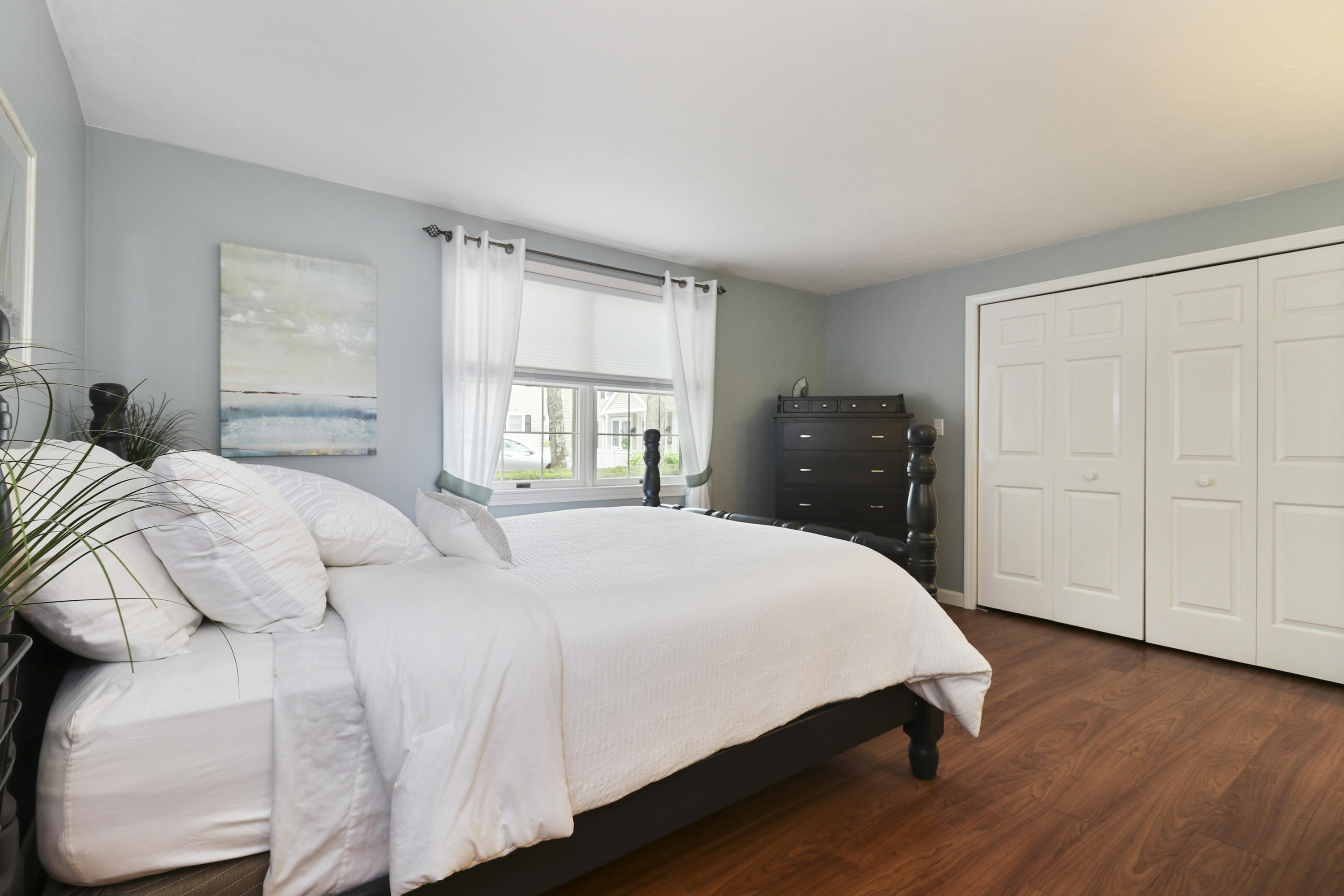 727 Main Street, Unit E1 Osterville, MA 02655 - Photo 14 of 20 a bedroom with a bed and wooden floor