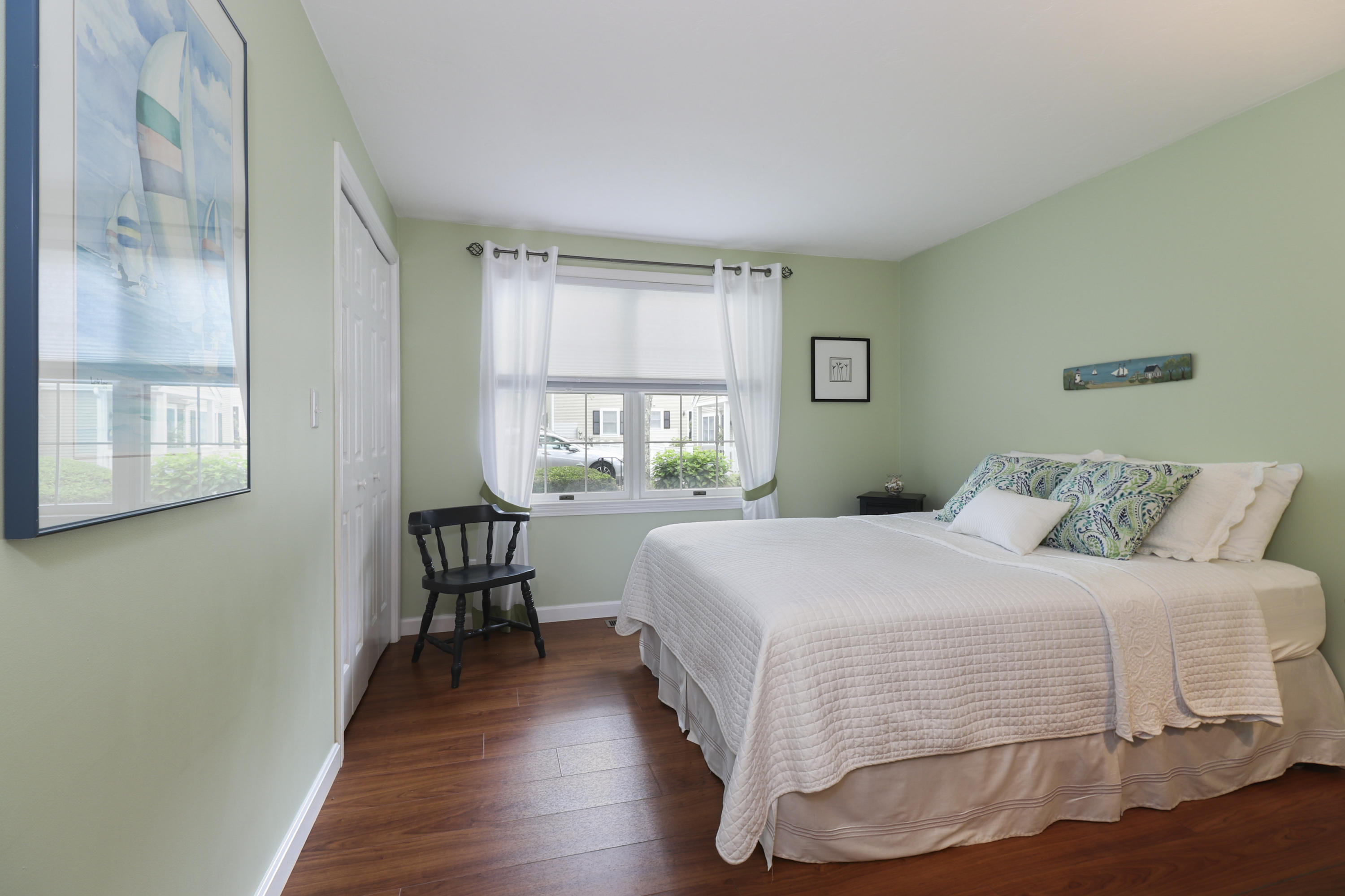 727 Main Street, Unit E1 Osterville, MA 02655 - Photo 16 of 20 a bedroom with a large bed window and a table