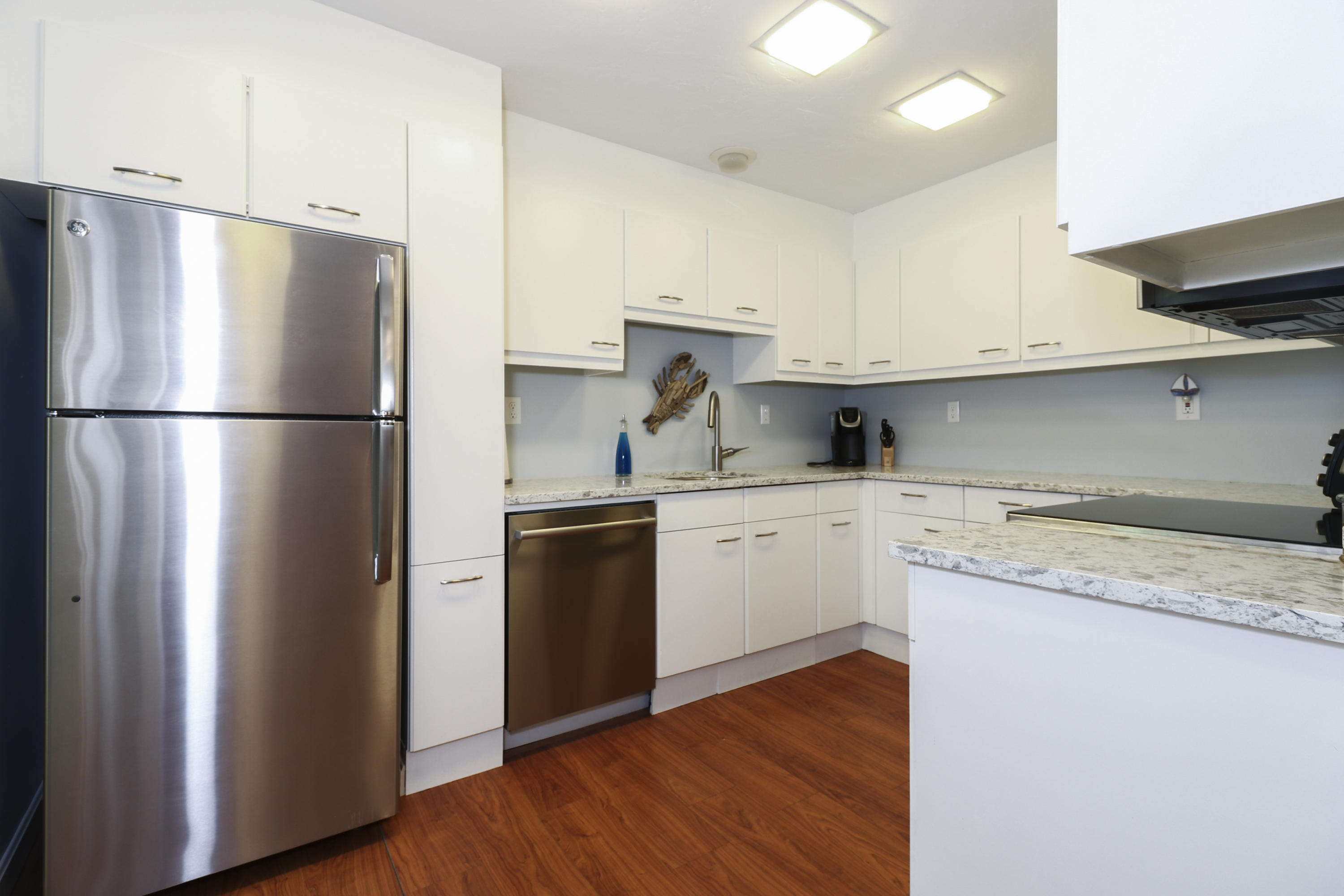 727 Main Street, Unit E1 Osterville, MA 02655 - Photo 9 of 20 a kitchen with a refrigerator sink and cabinets