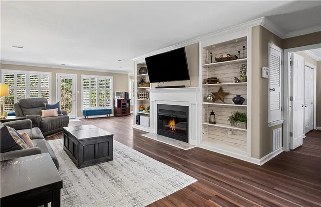 a living room with furniture a flat screen tv and a fireplace
