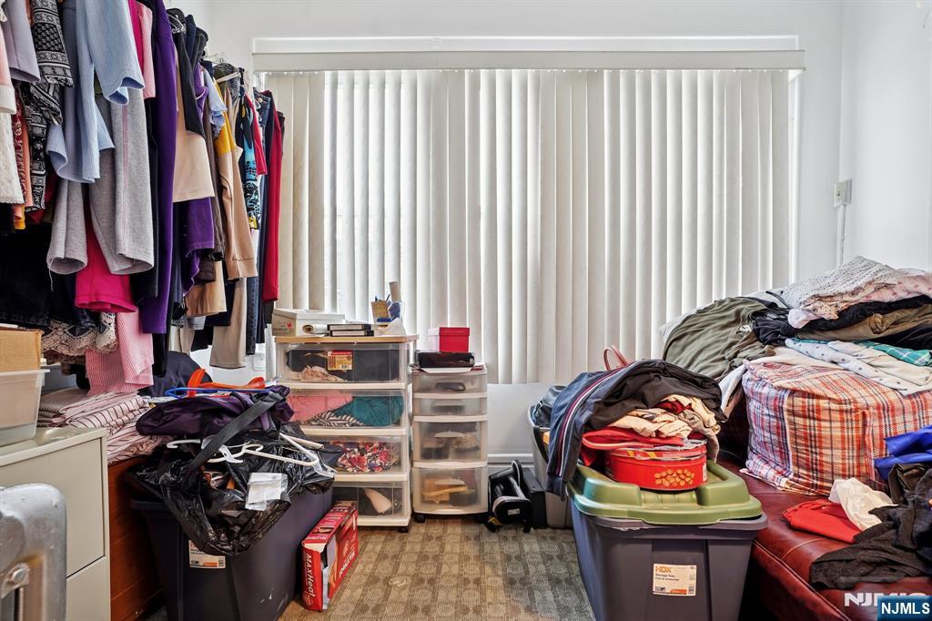 75 Coolidge Street Irvington, NJ 07111 - Photo 14 of 30 a view of walk in closet with clothes and shoes