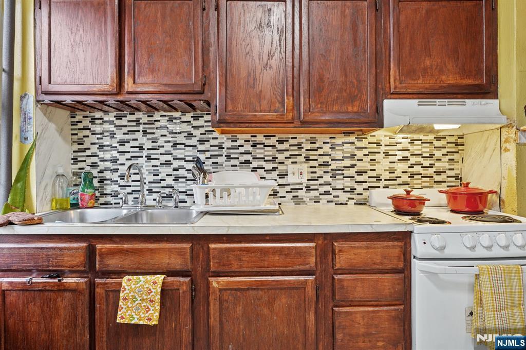 75 Coolidge Street Irvington, NJ 07111 - Photo 24 of 30 a kitchen with stainless steel appliances granite countertop wooden cabinets and a sink