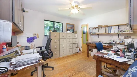 a view of a workspace with furniture and a window