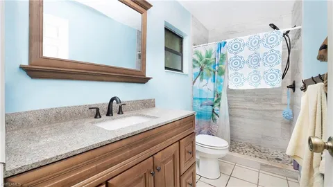 a bathroom with a granite countertop toilet sink and mirror