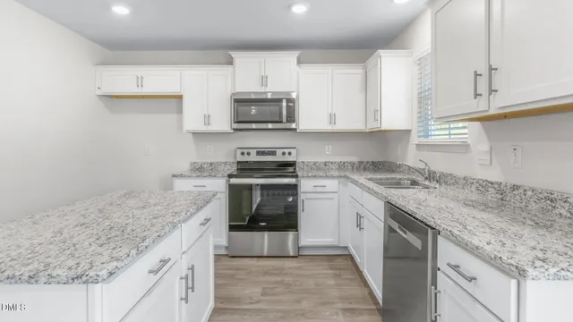 a kitchen with stainless steel appliances granite countertop a sink stove and cabinets