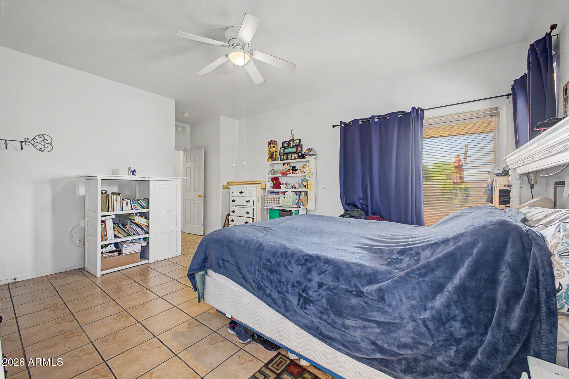 9730 West Payson Road Tolleson, AZ 85353 - Photo 16 of 57 a bed room with a bed and a tv