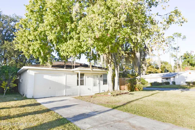 a white house that has tree in front of it
