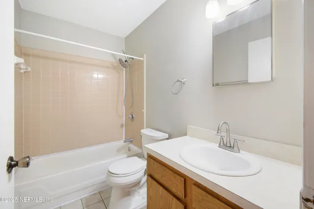 an empty room with chandelier fan and windows