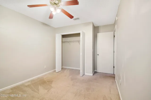 an empty room with a window and a fan