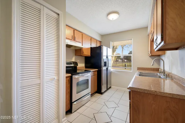 a kitchen with granite countertop a sink a stove and cabinets
