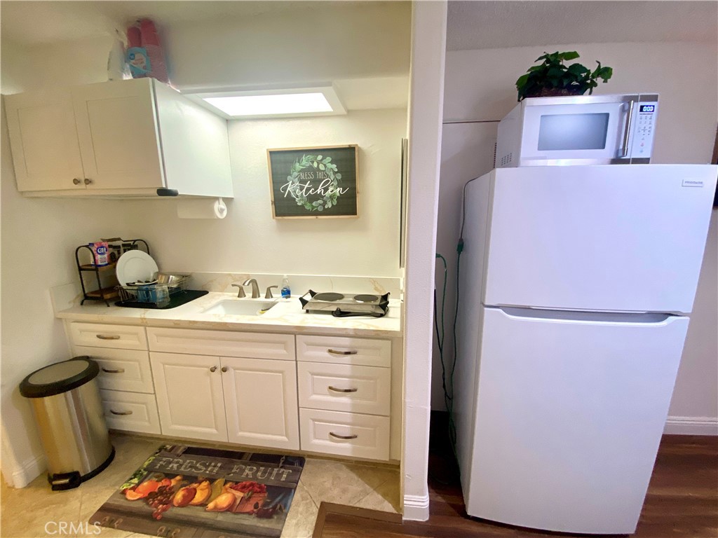 3112 W Avenue North, Unit F Palmdale, CA 93551 - Photo 2 of 5 a kitchen with a refrigerator and cabinets
