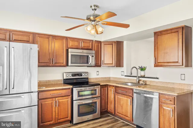 a kitchen with stainless steel appliances a stove a sink and a refrigerator