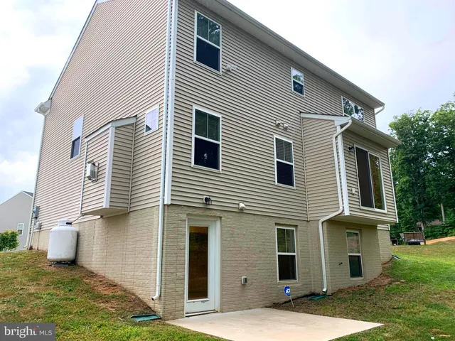 a view of a white house next to a yard