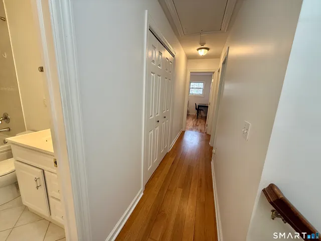 a view of a hallway with wooden floor and staircase