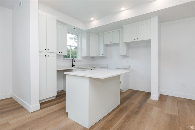 314 North 200 West Logan, UT 84321 - Photo 5 of 37 Kitchen featuring white cabinetry, light countertops, light wood-style flooring, a kitchen island, and recessed lighting