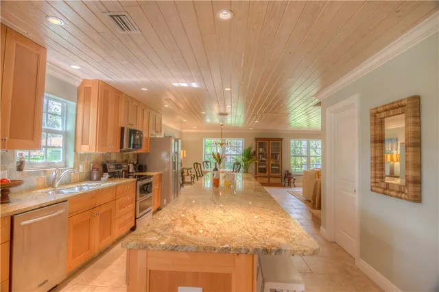 a large kitchen with kitchen island a large window in it