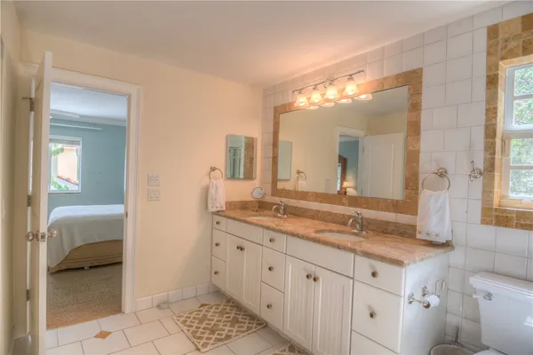 a spacious bathroom with a granite countertop sink and a mirror