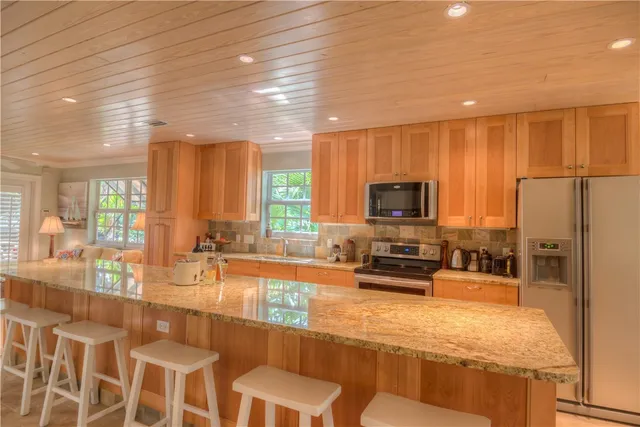 a kitchen with stainless steel appliances granite countertop a stove a sink and a refrigerator