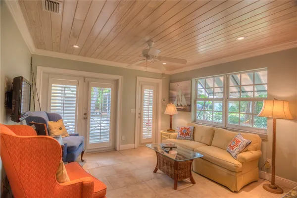 a living room with furniture a flat screen tv and a large window
