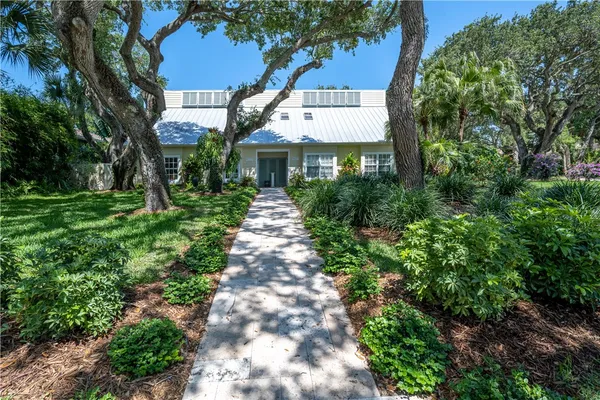 a front view of a house with a yard and fountain in middle