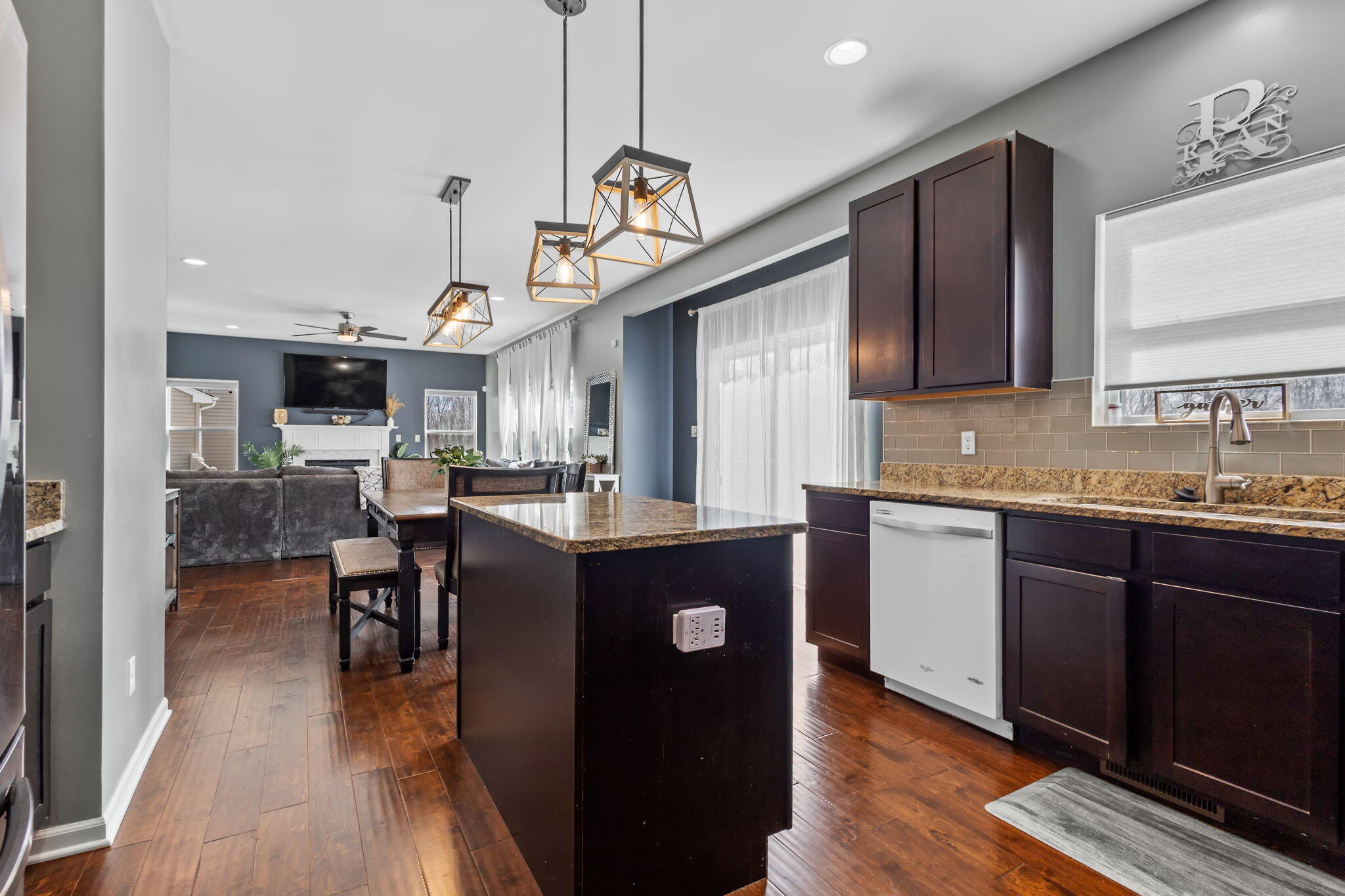 12938 Hayes Street Crown Point, IN 46307 - Photo 9 of 33 a kitchen with kitchen island granite countertop a sink cabinets and wooden floor