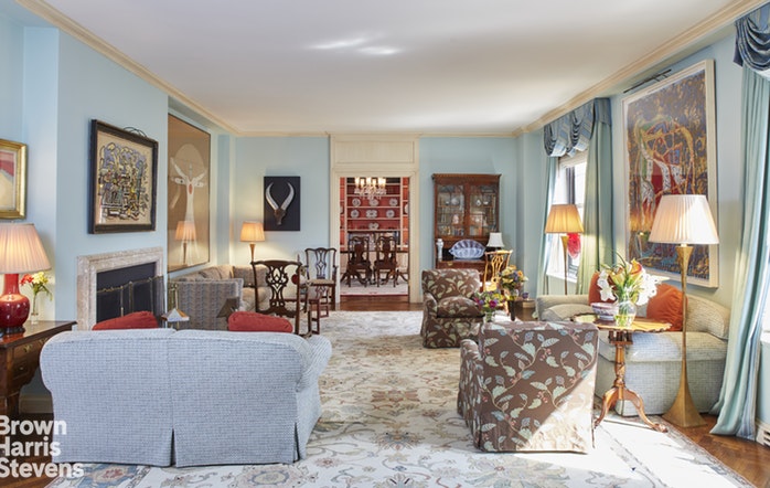a living room with fireplace furniture and a large window