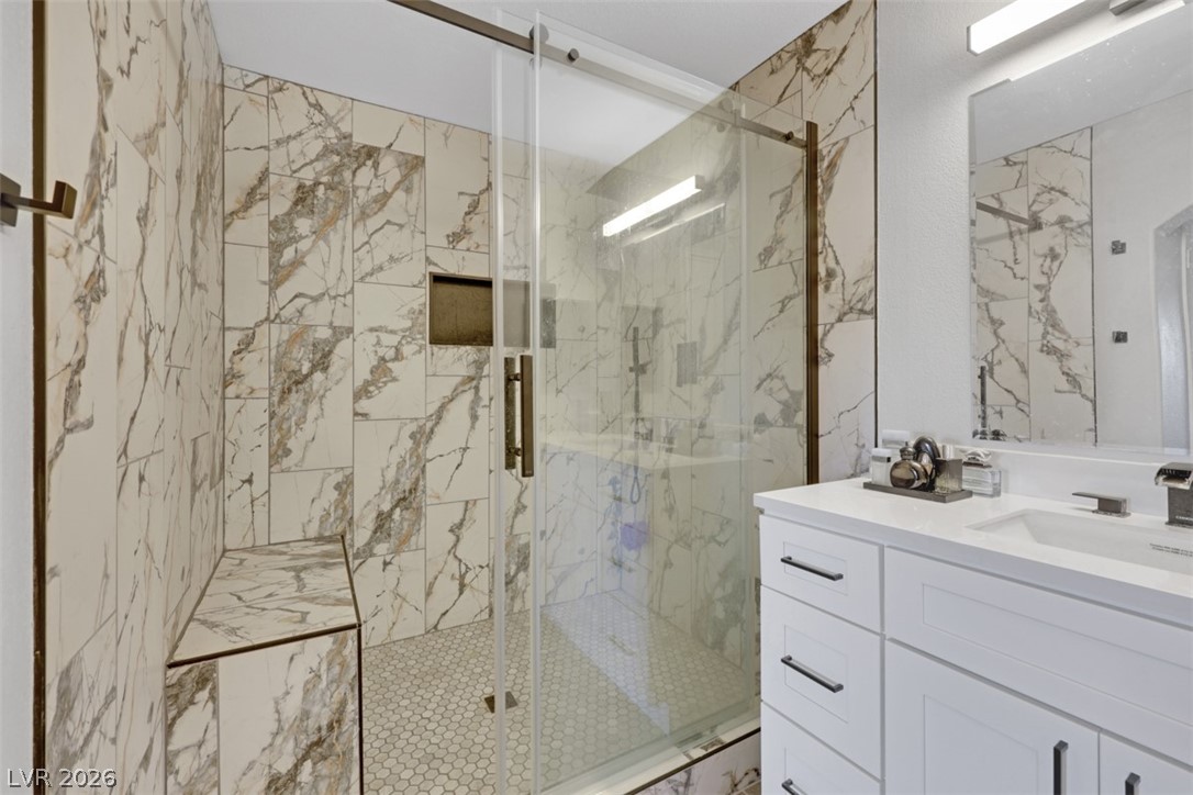 698 South Racetrack Road, Unit 1614 Henderson, NV 89015 - Photo 31 of 35 Marble-clad shower with glass enclosure and sleek vanity create a sophisticated bathing experience.