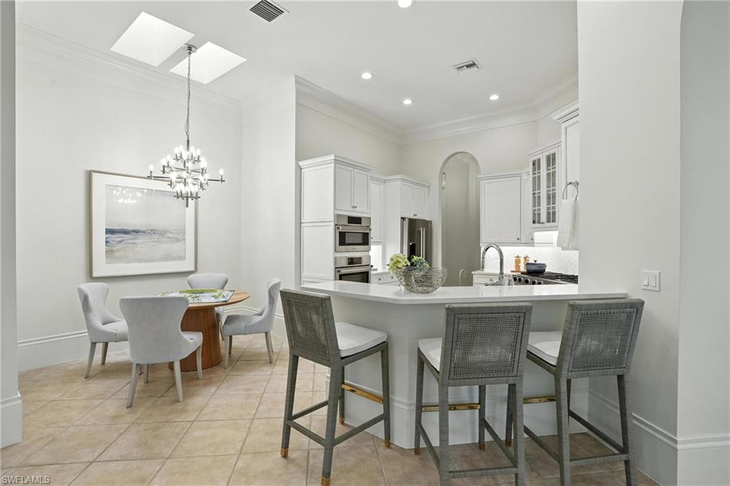 2547 Avila Lane Naples, FL 34105 - Photo 11 of 49 a dining room filled chandelier and wooden floor