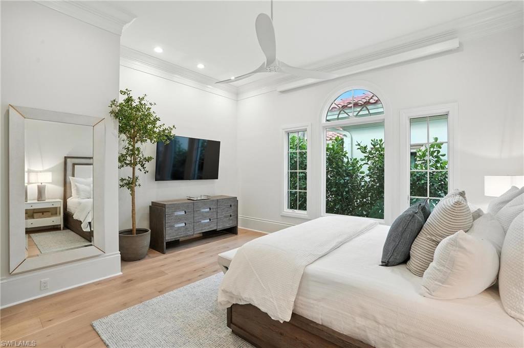 2547 Avila Lane Naples, FL 34105 - Photo 16 of 49 a bedroom with a bed and a flat screen tv