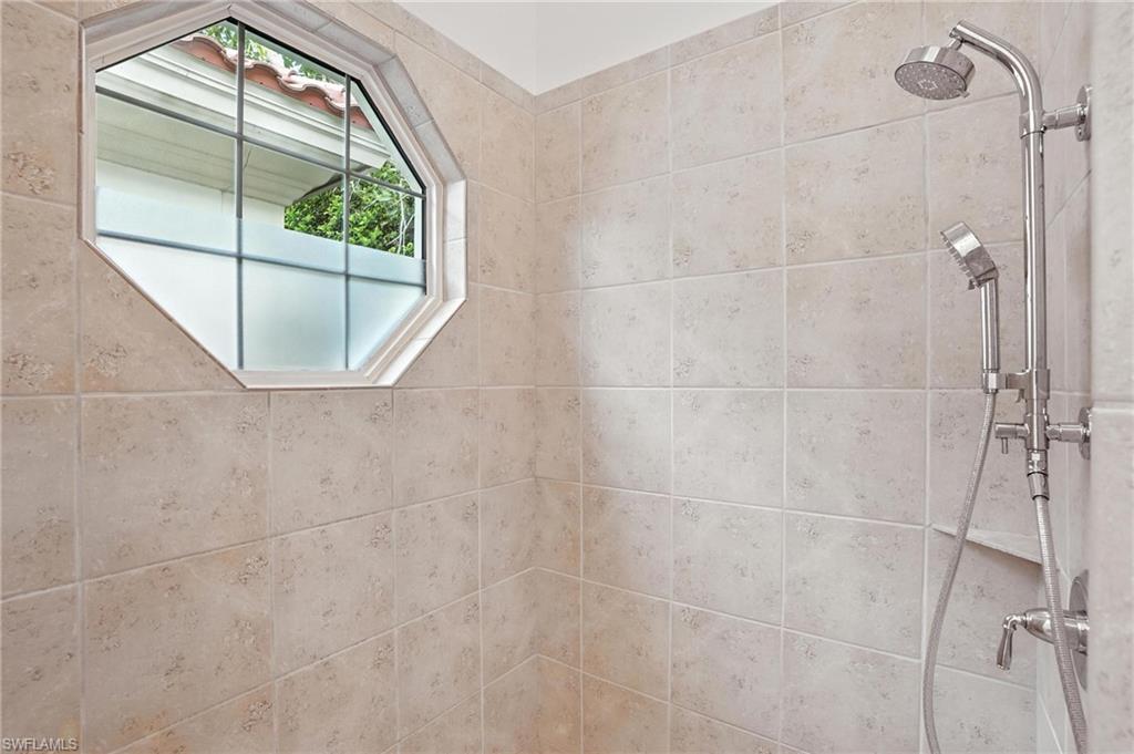 2547 Avila Lane Naples, FL 34105 - Photo 20 of 49 a bathroom with a glass shower door and a window