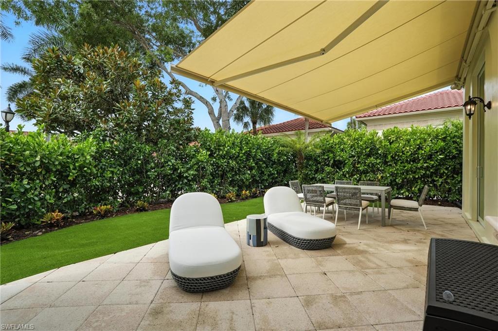 2547 Avila Lane Naples, FL 34105 - Photo 35 of 49 a patio with a table and chairs