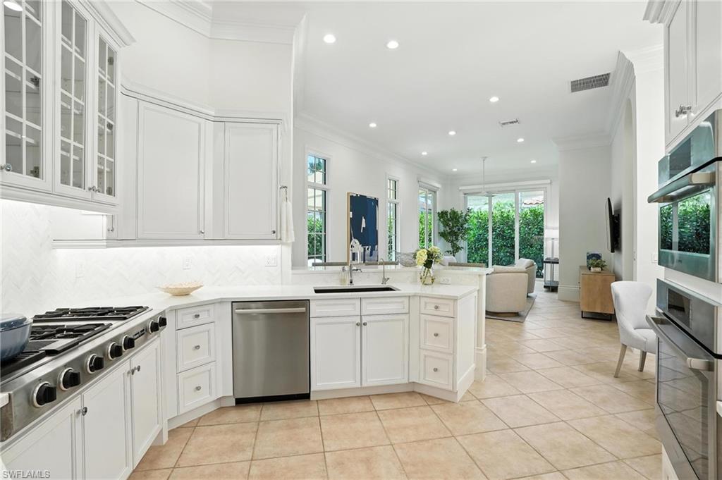 2547 Avila Lane Naples, FL 34105 - Photo 7 of 49 a kitchen with a sink stove and cabinets