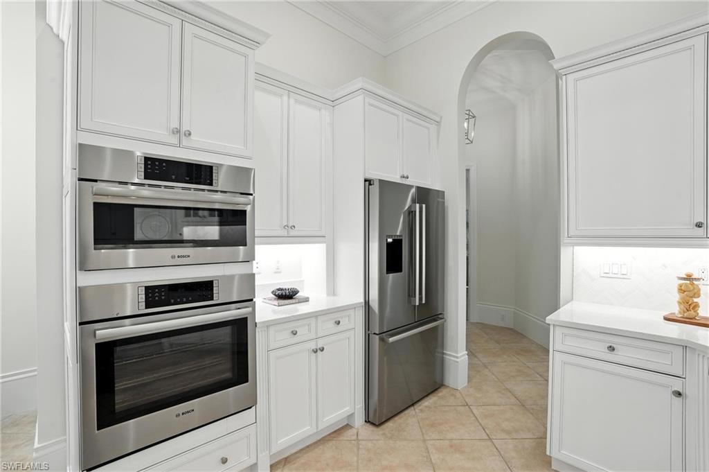 2547 Avila Lane Naples, FL 34105 - Photo 9 of 49 a kitchen with stainless steel appliances a stove a microwave and a refrigerator