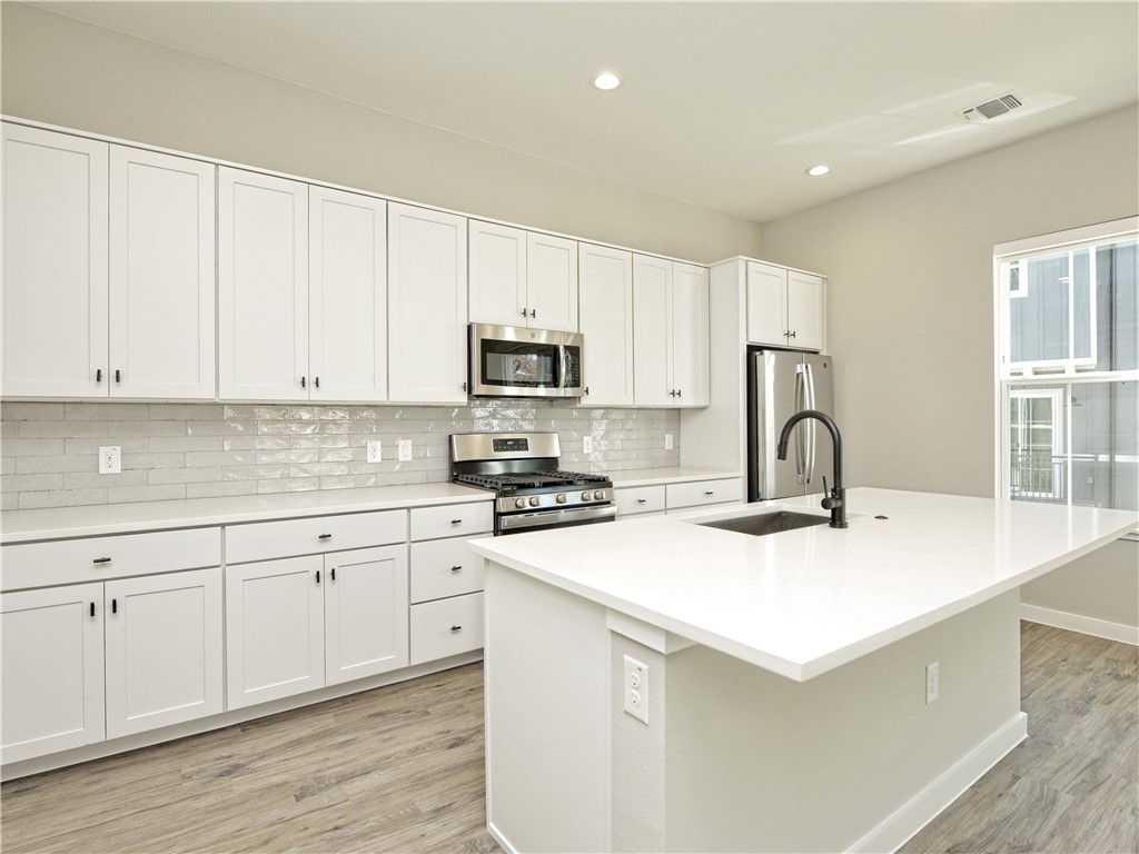 3809 Valley View Road, Unit 15 Austin, TX 78704 - Photo 5 of 30 a kitchen with sink a microwave and cabinets