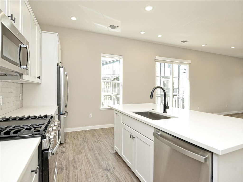 3809 Valley View Road, Unit 15 Austin, TX 78704 - Photo 6 of 30 a kitchen with sink a stove and cabinets