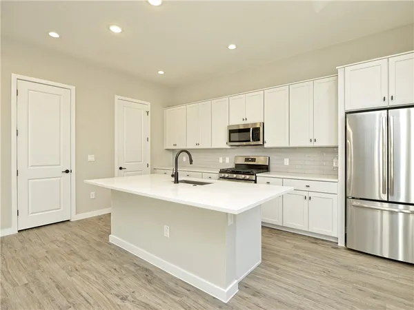 a kitchen with sink cabinets and wooden floor