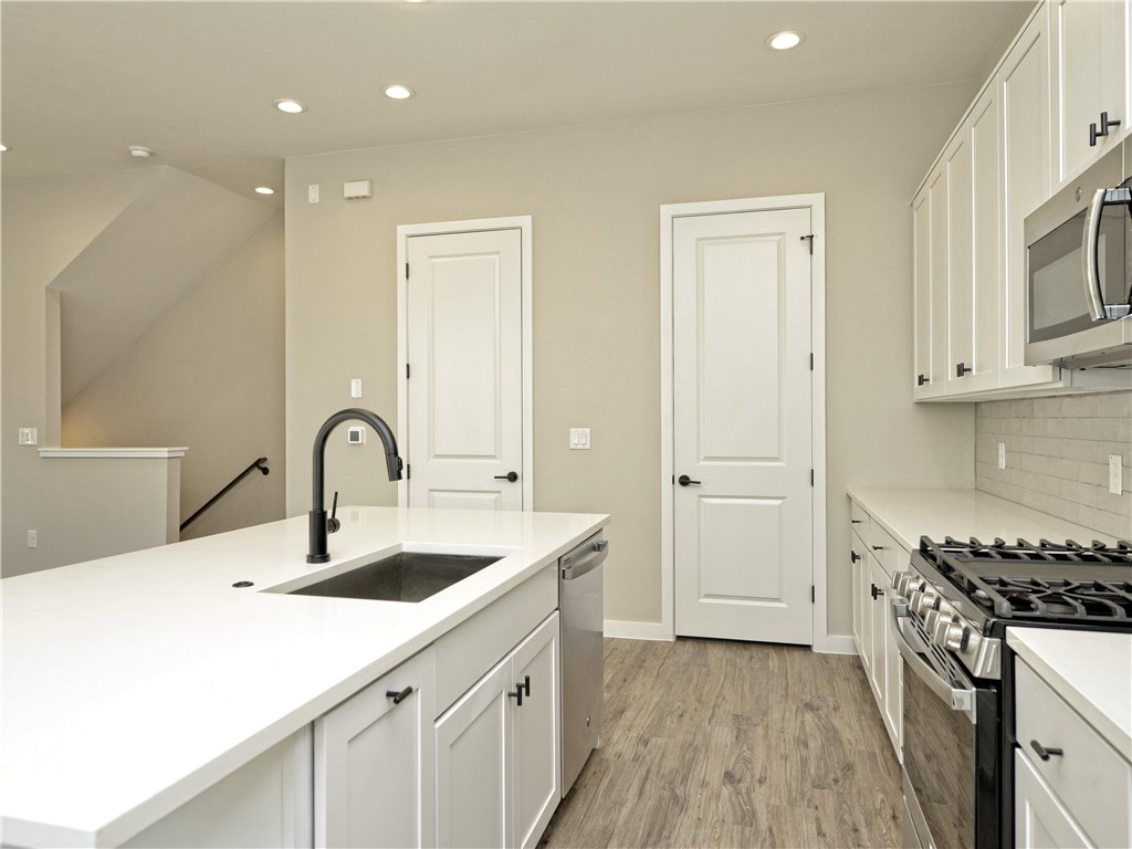 3809 Valley View Road, Unit 15 Austin, TX 78704 - Photo 8 of 30 a kitchen with sink cabinets and wooden floor