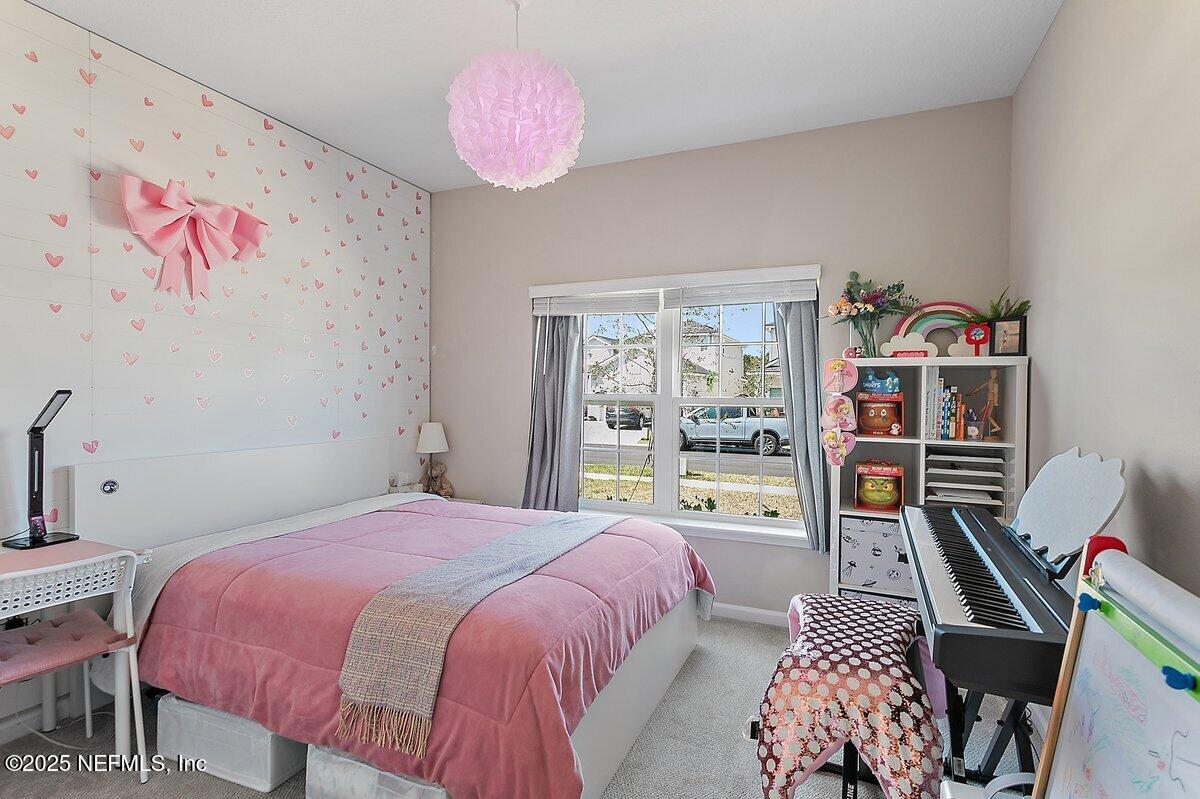 367 Brookgreen Way St. Augustine, FL 32092 - Photo 10 of 27 a bedroom with a bed and a bookshelf with wooden floor