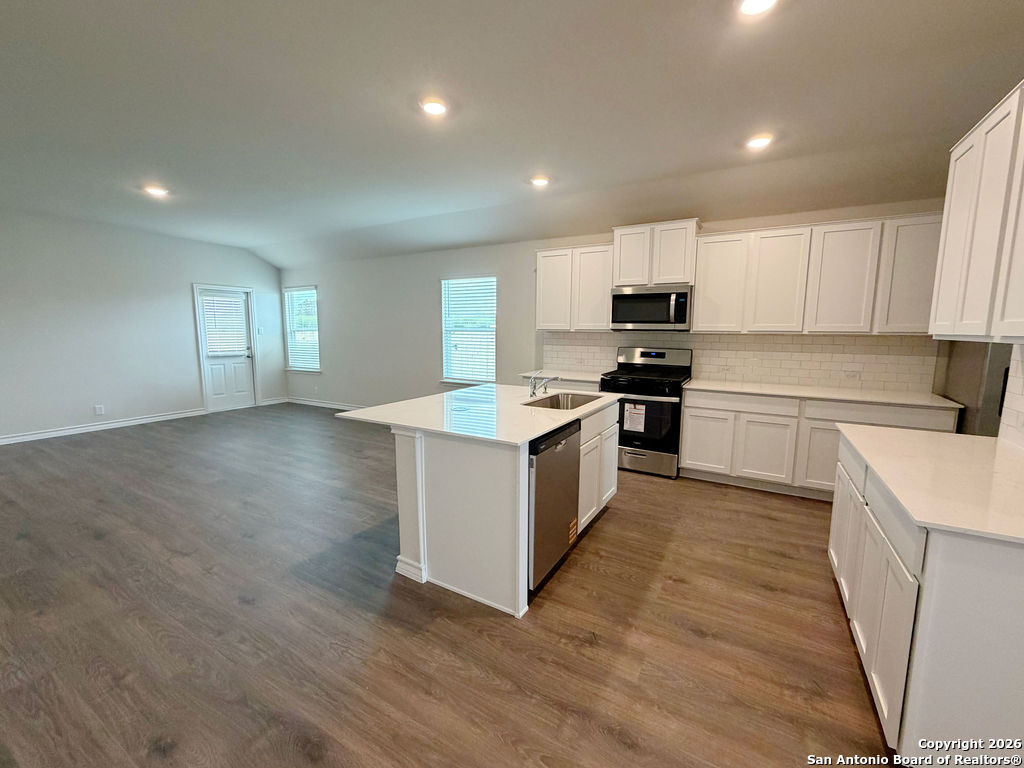 607 Fluted Cibolo, TX 78108 - Photo 14 of 50 a kitchen with granite countertop a stove top oven sink and cabinets
