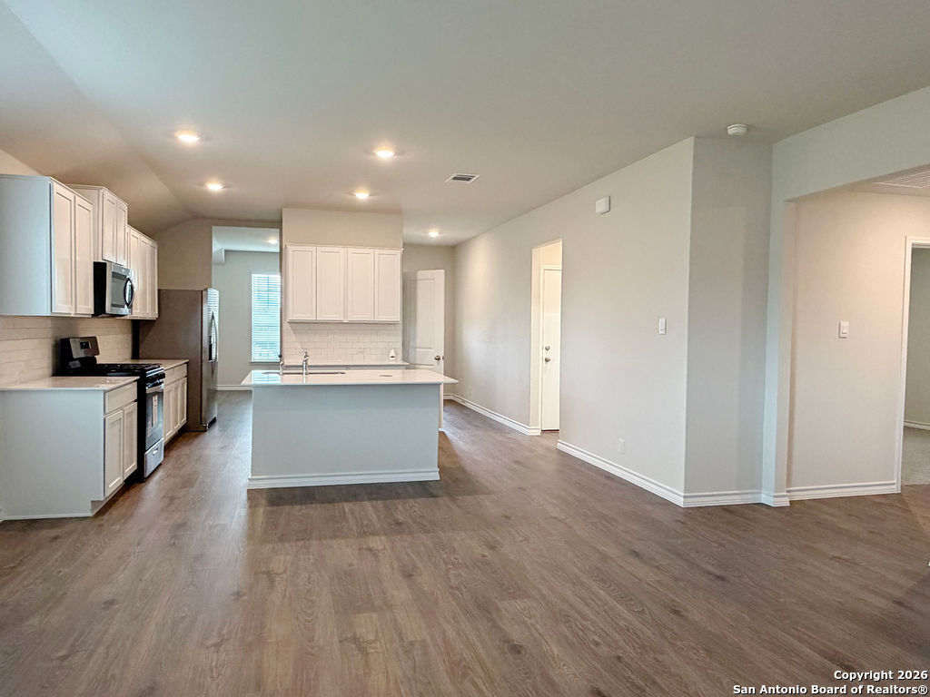 607 Fluted Cibolo, TX 78108 - Photo 28 of 50 a view of kitchen with kitchen island granite countertop stainless steel appliances counter space and wooden floor