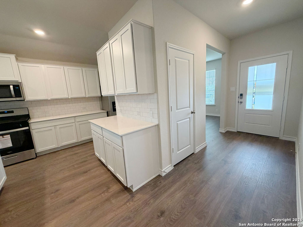 607 Fluted Cibolo, TX 78108 - Photo 5 of 50 a kitchen with a sink a stove cabinets and wooden floor