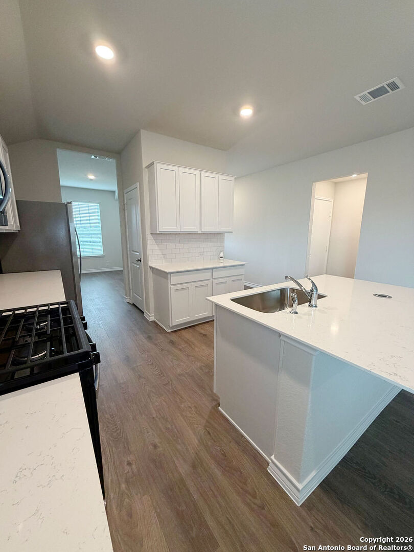 607 Fluted Cibolo, TX 78108 - Photo 7 of 50 a kitchen with a sink stove and cabinets
