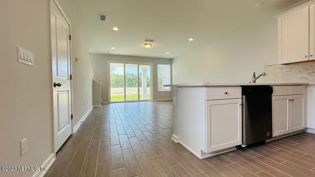 a view of a kitchen with wooden floor and electronic appliances