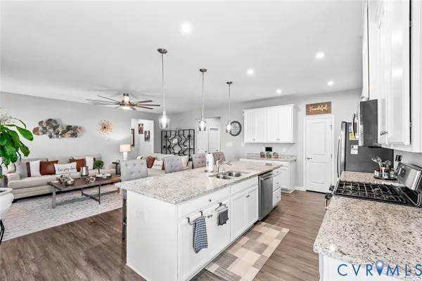 a large kitchen with kitchen island a large counter top space a sink stainless steel appliances and cabinets