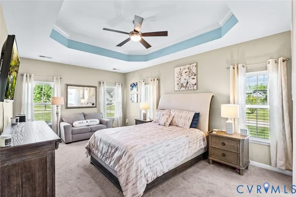 a bedroom with a large bed and a chandelier
