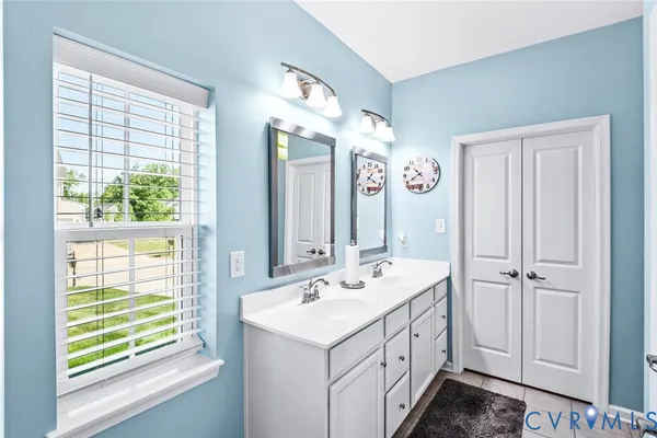 a bathroom with a sink a mirror and a window