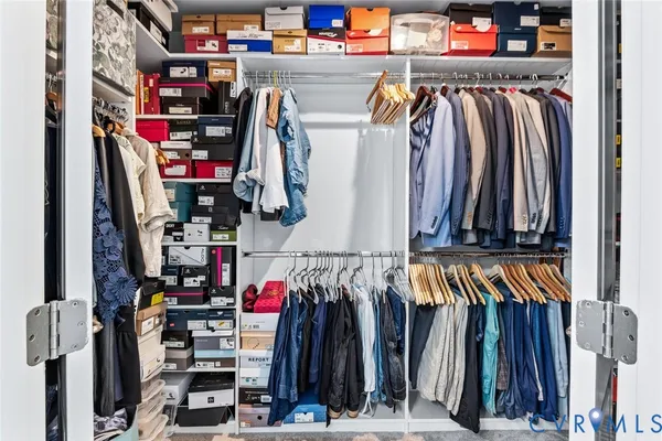 a view of walk in closet with clothes and shoes
