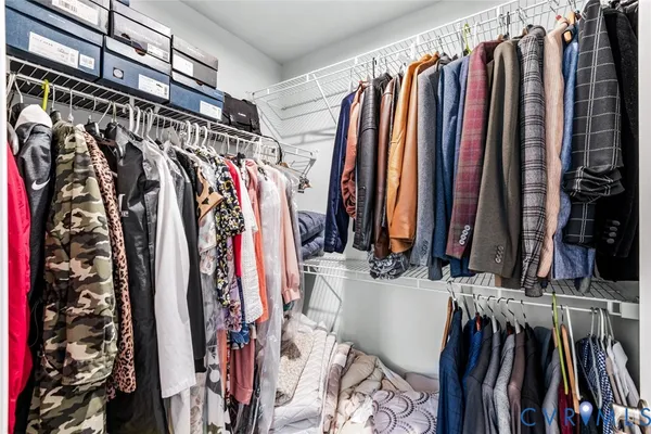 a view of walk in closet with clothes